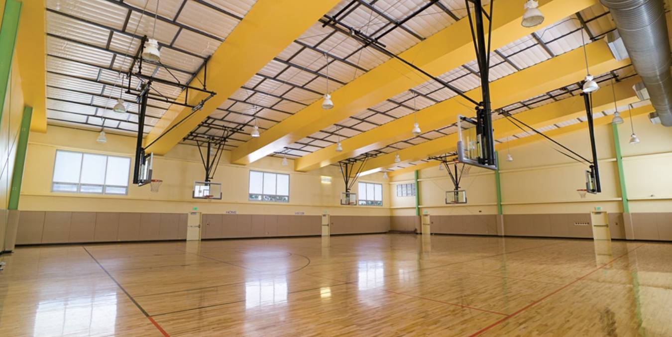 a basketball court with yellow walls and hardwood floors